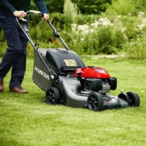 a man mowing the lawn with a HONDA HRN 536 VK Petrol Lawnmower